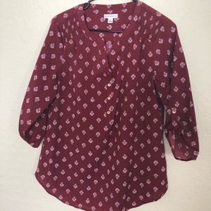 Burgundy red top with fleur-de-lis pattern.